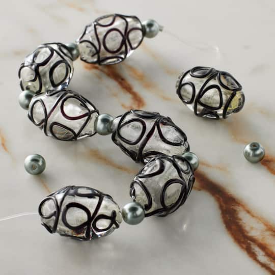 12 Packs: 7 ct. (84 total) Black Lines Lampwork Glass Oval Bead Mix by Bead Landing™